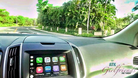 POV car dashboard view driving past palm trees outdoors with ATK Girlfriends screen