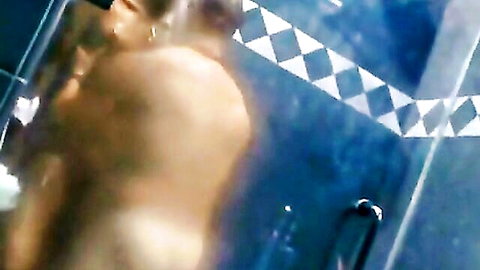Curvy ebony woman nude in steamy shower, back view