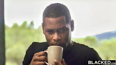 Muscular black man sipping from white mug outdoors with BLACKED watermark