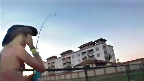 Topless woman fishing nude at sunset by beach resort, wild party cams