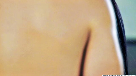 Sexy fair-skinned brunette with long black hair shows bare shoulder in black lingerie tease
