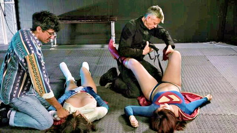 Brunette Supergirl cosplayer with big tits has shaved pussy exposed legs spread by two men ready for anal fuck