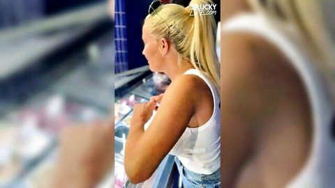 Skinny blonde with big tits in tight white tank top reaching at ice cream counter