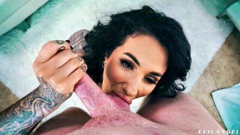 Tattooed brunette giving intense blowjob close-up