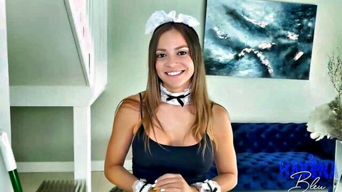 Smiling tanned brunette Latina maid showing huge tits cleavage in black top