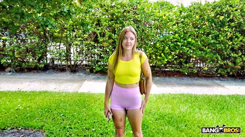 Tattooed blonde babe in tight yellow top and pink booty shorts flaunting juicy ass outdoors