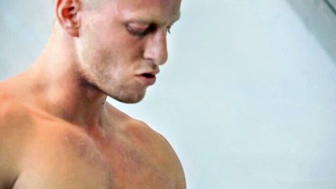 Shirtless muscular platinum-haired man in poolside setting