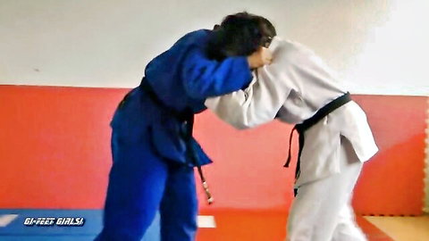 Two Japanese girls in kimonos grappling intensely during karate practice