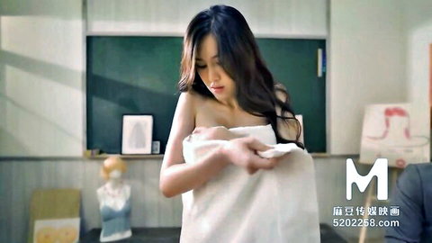 Asian woman in towel in classroom from Chinese film handjob scene with big tits
