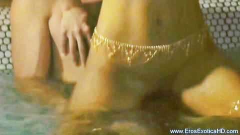Exotic woman with gold waist chain in steamy water during Nuru massage