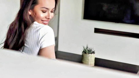 Petite Asian teen Tia in white top unwinding on couch