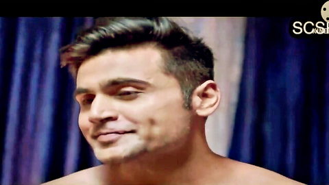 Shirtless muscular Indian hunk smiling seductively with toned chest exposed