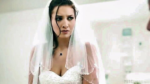 Busty bride Bella Rolland in low-cut wedding dress with veil, showing deep cleavage