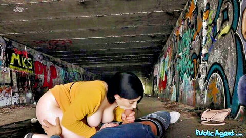 Amilia Onyx exposes big tits and gives blowjob in public tunnel for cash