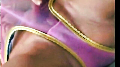 Sexy woman in sheer purple blouse with gold trim, teasing upper body view