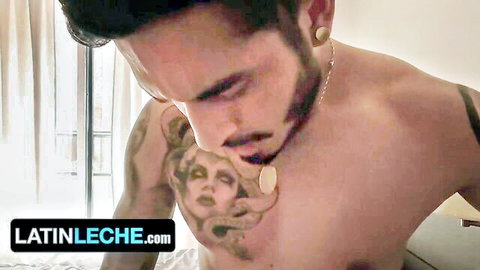 Tattooed Latino man with intense gaze and muscular chest in sensual close-up
