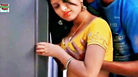 Indian couple in passionate embrace, woman in yellow saree blouse