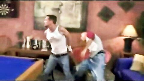 Two muscular men in intense gay struggle, one grabbing from behind in rough scene