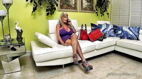 Blonde MILF with fake boobs in tight purple dress, sitting solo