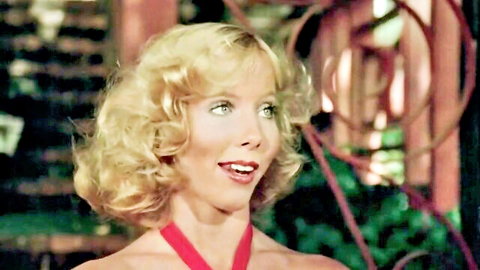 Georgina Spelvin smiling in red halter top, blonde curls