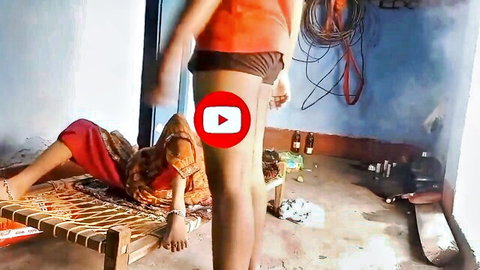 Indian man in orange shorts stands over saree-clad woman on bed groping her exposed thighs and pussy