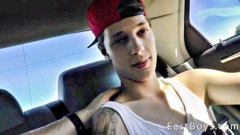 Handsome gay twink in tank top smiling selfie in car with tattoos