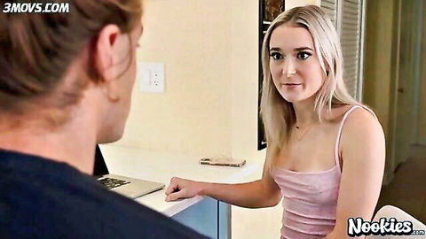 Skinny blonde e-girl in tight pink tank top with cleavage flirts with guy at laptop counter