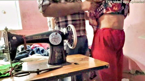 Desi Indian aunty in red skirt adjusting clothes near sewing machine
