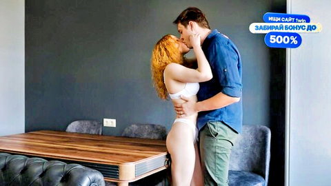 Redhead in white lingerie passionately kissing muscular man