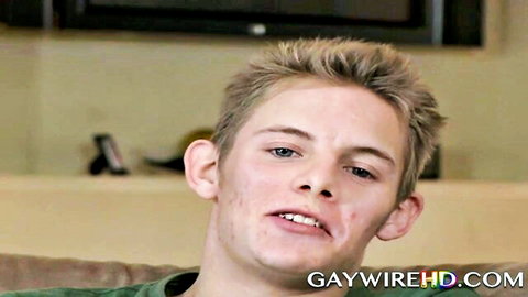 Blond white twink smiling on couch in interracial gay hardcore scene