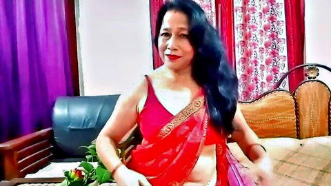 Sexy Indian MILF posing in red saree with exposed midriff and curves in homemade bedroom tease