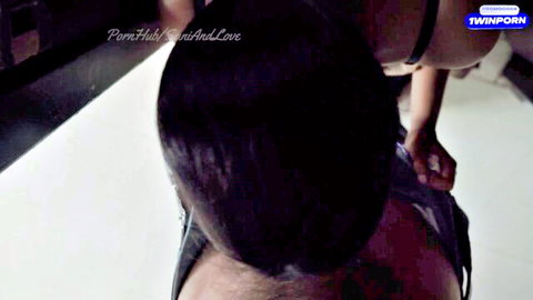 South Asian babe in black harness bent over with hands grabbing her hips from behind