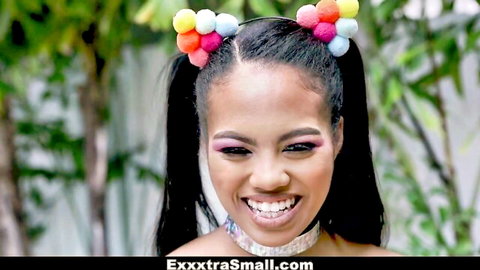 Petite black girl with colorful pigtails and choker smiles outdoors