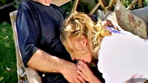 Blonde woman giving passionate outdoor blowjob to man