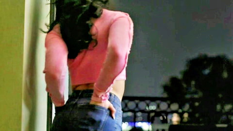 Petite Jane Wilde teases ass in pink top and tight jeans from behind