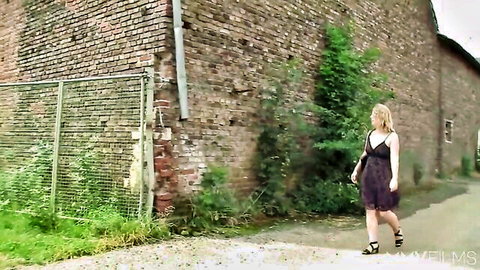 Farmers Wifey in purple slip dress walking outdoors, plump blonde model