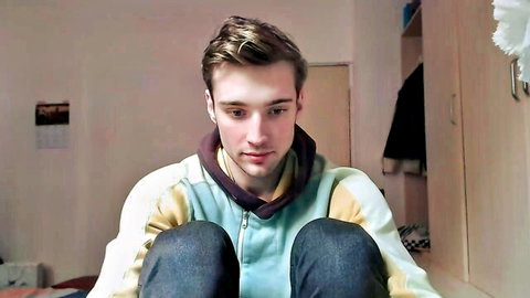Young Caucasian guy in hoodie sits teasingly for gay blowjob sex video