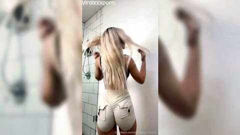 Curvy blonde babe poses with big juicy ass in tight white booty shorts in bathroom mirror
