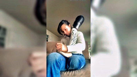 Asian student teasing with large black dildo in casual sweater and jeans