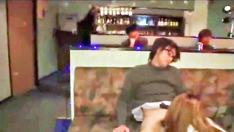 Redhead woman eagerly sucking throbbing cock on bar couch in public club