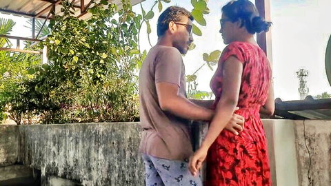 Indian couple embracing outdoors, woman in sexy red dress