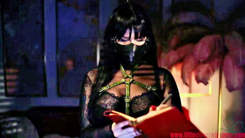 Boss lady in gas mask and black harness writes punishment notes, femdom tease