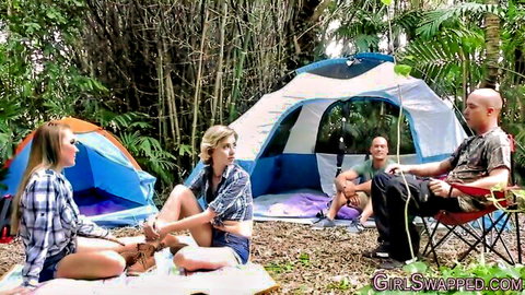 Blonde babes in plaid shirts and shorts tease guys at outdoor campsite tents swap party