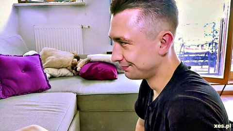 Handsome Polish guy smiling on couch in black t-shirt ready for action