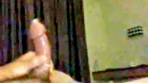 Closeup of woman's hand with red nails stroking thick erect cock in room