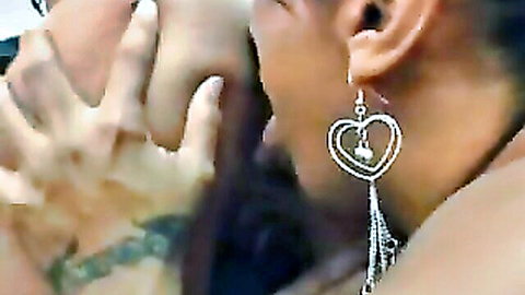 Close-up of Brazilian woman with heart earrings and man's hand on her face