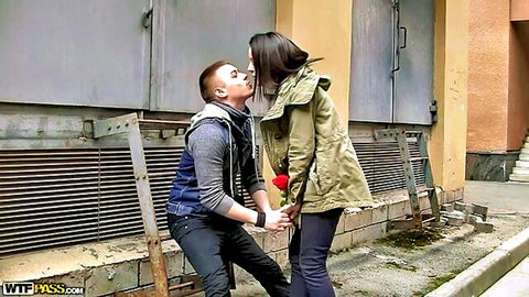 Izzy Jay sharing romantic kiss with partner outdoors, holding rose