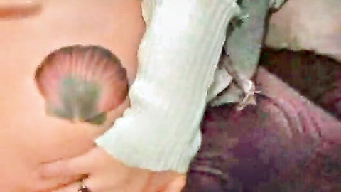 Curvy woman in pulled-up sweater exposing skin with iridescent shell accent