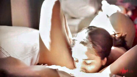 Asian lesbian licks shaved pussy of busty brunette in intense closeup bed scene