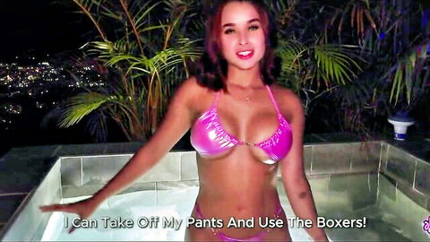 Young redhead babe in shiny pink bikini top with big tits posing by outdoor hot tub